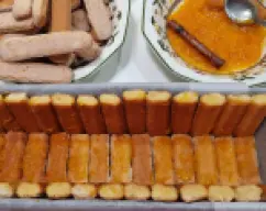 Step <p>* Forre el molde con bizcochitos mojados en el almíbar y coloquelos como se ve en la foto (no los emborrache demasiado o se les irán partiendo antes de ponerlos)</p><p>Tendrá que cortar los bizcochos para ir adecuabdolos al molde que tenga y antes de emborracharlos</p> illustration